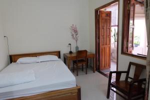 a bedroom with a bed and a table and a chair at Moon house tropical garden - Valentine in Nha Trang
