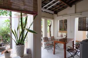 a porch with a table and chairs and a plant at Moon house tropical garden - Valentine in Nha Trang
