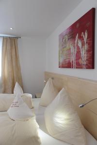 a hotel room with white pillows on a bed at Hotel-Restaurant Steuermann in Karlsruhe