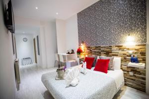 een slaapkamer met een groot wit bed met rode kussens bij Hostal Adis in Madrid