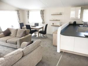 a kitchen and living room with a couch and a table at Mikanda Lodge in Clacton-on-Sea