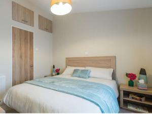 a bedroom with a large bed with a blue blanket at Mikanda Lodge in Clacton-on-Sea