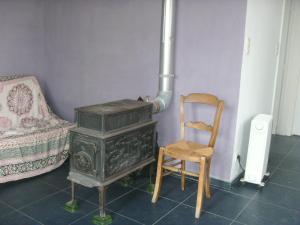 een kamer met een fornuis en een houten stoel bij Ferme Lenfant Rez in Ville-Pommeroeul