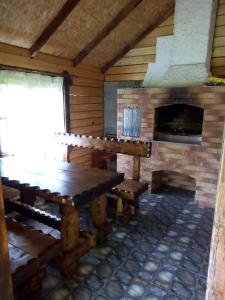 Habitación con mesa de madera y chimenea. en Едельвейс, en Slavske