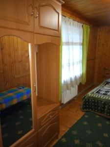 Cabaña con cama y ventana en una habitación en Едельвейс, en Slavske