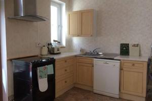 a kitchen with a black and white stove top oven at Millbrook in Helston