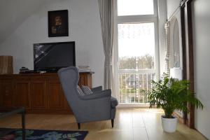 a living room with a chair and a television at Farm stay Hof auf der Wurp in Harrierwurp