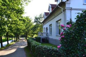 Una casa blanca con flores rosas a un lado. en Farm stay Hof auf der Wurp, en Harrierwurp