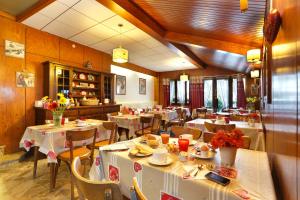 un comedor con mesas y sillas con comida. en HOTEL LES MARRONNIERS, en Thonon-les-Bains