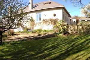 a white house with a fence in front of a yard at Millbrook in Helston