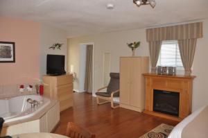 a living room with a tub and a fireplace at Motel Bel-Eau in Montebello