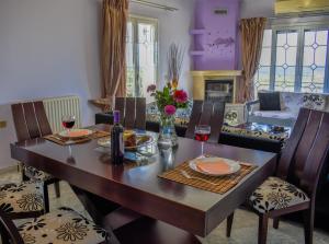 a dining room with a table and chairs with wine glasses at ANEMOS HOLIDAYS HOUSE in Kipseli