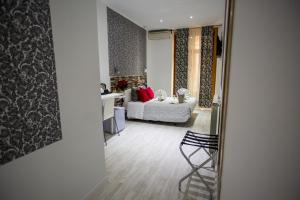 een woonkamer met een bed en een stoel bij Hostal Adis in Madrid