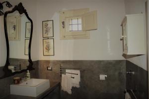 y baño con lavabo y espejo. en CASADORATA buen retiro vista mare en Donnalucata