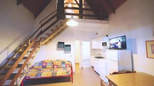 a living room with a staircase and a kitchen at Villetta 6 in Lido degli Estensi