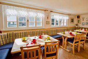 a restaurant with two tables and chairs and windows at Chalet Schäfer s vyhřívaným bazénem se slanou vodou in Harrachov