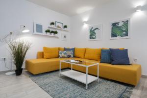 un sofá amarillo en una sala de estar con mesa en Holiday Apartments Split, en Split