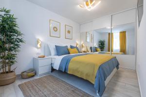 - une chambre dotée d'un grand lit avec des oreillers jaunes et bleus dans l'établissement Holiday Apartments Split, à Split