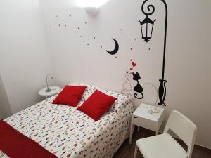 Un dormitorio con una cama con almohadas rojas y una lámpara. en La Casa di Fabio, en Roma