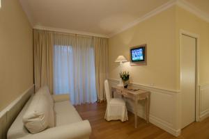 ein Wohnzimmer mit einem weißen Sofa und einem Tisch in der Unterkunft Hotel Antico Mulino in Scorzè