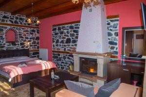 a bedroom with a bed and a fireplace at Enastron in Palaios Agios Athanasios