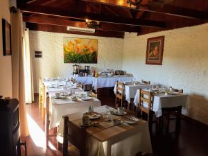 een eetkamer met tafels met witte tafelkleden bij Casa Calfu in Santa Cruz