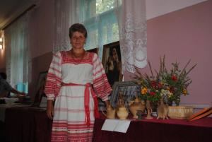 een vrouw die naast een tafel met vazen staat bij Koryakivskyi Rai in Dmitrenki