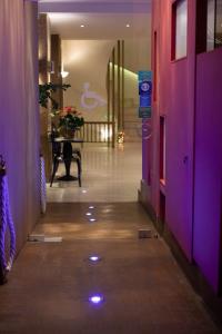 a hallway with purple walls and a table with flowers at Nidimos Hotel in Delfoi