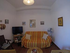 a living room with a couch and a tv at SUN VITO - Casa Vacanze vicino la Spiaggia in San Vito lo Capo