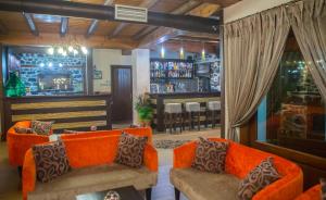 a living room with orange couches and a bar at Enastron in Palaios Agios Athanasios +38 photos