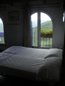 a bedroom with a bed and a large window at B&B Nelly G in Carbuta