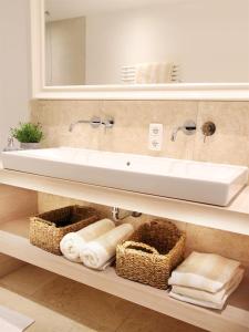 a bathroom with a sink and towels on a shelf at Ferienwohnungen Beargzit in Bad Hindelang