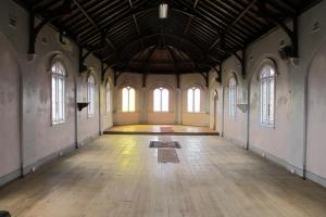 an empty room with a wooden floor and windows at Holmhurst Guest House in Bathurst