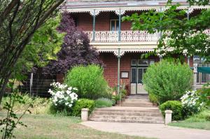 a red brick house with a staircase leading to the front door at Holmhurst Guest House in Bathurst