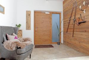 a living room with a chair and a wooden door at Appartementhaus Mountain Room in Altenmarkt im Pongau