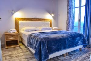 a bedroom with a large bed with a blue blanket at Villa Francesca in Mikonos