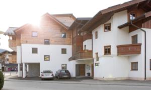 dwa samochody zaparkowane przed budynkiem w obiekcie Appartementhaus Reiter w mieście Altenmarkt im Pongau