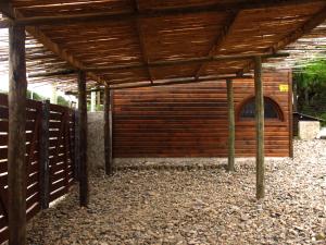 una pérgola de madera con una puerta en un patio en Excelente Cabaña Cumbre del Diablo 2, en Punta del Diablo