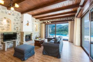 a living room with a couch and a fireplace at Villa Asigonia with Heated Pool & Whirlpool in Asigonía