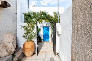 um corredor com uma porta azul e vasos de plantas em The Arch House. A Romantic Break em Zákros