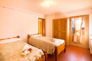 um quarto com duas camas e uma janela em Chalet Dei Rododendri em Valdisotto