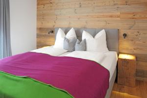 een slaapkamer met een groot wit bed met een paarse deken bij Appartementhaus Reiter Village Room in Altenmarkt im Pongau