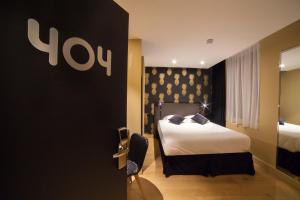 Habitación de hotel con cama y cartel en la pared en La Valiz en Lille