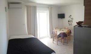 a bedroom with a bed and a table with chairs at Apartmani Luna in Novalja