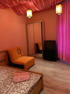 una camera con letto e TV rosa tende di 5Kotliarska Moisha House a Lviv