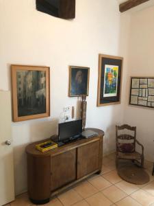 a room with a desk with a television and paintings at Casa María in Samper del Salz