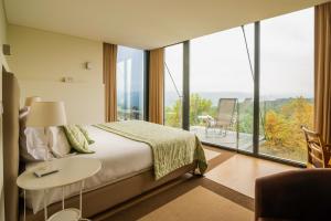 a bedroom with a bed and a table with a lamp at Paço da Torre de Figueiredo das Donas in Figueiredo das Donas