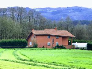 ein Haus auf einem Feld neben einem Grasfeld in der Unterkunft Villa Bosque Albite in Llanera