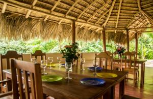 uma sala de jantar com uma mesa e cadeiras e um tecto de palha em Villa Noria em Las Terrenas