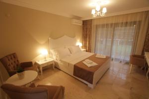 a bedroom with a bed and a table and chairs at Alaçatı Çınar Boutique Hotel in Alaçatı +51 photos